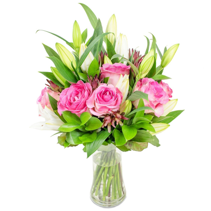 A carefully balanced floral composition centred on deep-pink roses and white lilies is presented in a clear, tapered glass vase, isolated against a pristine white studio background so every detail is visible. The large roses dominate with full, open faces-petals layered from blush at the edges to a rich fuchsia near the heart-exhibiting a plush, velvety texture that suggests both warmth and refinement. Intermixed are tall white lily buds, their elongated forms tensioned between reserve and bloom: several remain tightly closed, promising a future unfurling, while a few have just begun to reveal inner white trumpets and subtle green tips. The bouquet's volume comes from an abundance of greens-broad, glossy leaves that anchor the silhouette, alongside smaller, glossier rounded leaves and delicate sprigs that add movement. Darker burgundy or reddish-brown accents appear as small buds or foliage, introducing shadowed contrast and tactile interest throughout the mass of colour.

The transparent vase shows the clean-cut stems beneath clear water, the composition's symmetry maintained by the vase's slightly flared rim and sturdy base. The lighting is bright and even, emphasising the freshness of each stem and the soft sheen on the petals and leaves; together the colours read as celebratory and elegant. As a Canonbury florist might recommend, this bouquet suits a range of occasions-anniversary tables, welcoming a guest at home near Canonbury Square or gifting for a birthday after browsing the nearby market on Essex Road. The overall impression is of expert floral craftsmanship: fragrant, visually generous and composed to bring light and calm into a room while remaining unmistakably fresh.