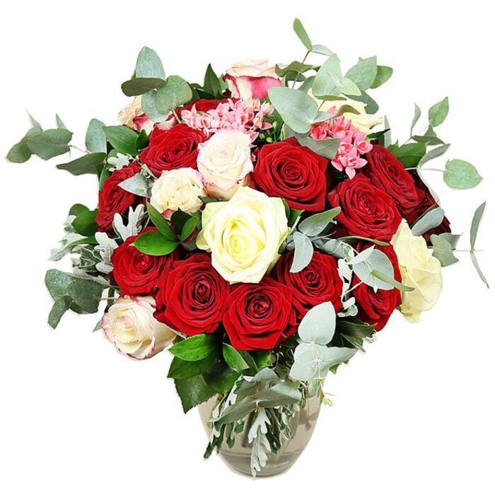 A richly detailed rose arrangement, photographed against a crisp white background, showcases the careful craftsmanship of an experienced Canonbury florist. Anchored in a simple clear glass vase with a gently bulbous base that narrows at the neck, the bouquet rises in a full, rounded dome, giving the impression of abundance without feeling overcrowded. At its core, velvety red and vivid scarlet roses are packed closely together, their petals spiralling inward and outward in various stages of bloom, from tight buds brimming with promise to wide, open flowers that seem to bask in the light. Between these passionate tones, clusters of creamy white and soft ivory roses are threaded thoughtfully, along with a few roses whose outer petals are edged with the faintest whisper of pale pink, like a blush caught across porcelain. Interspersed throughout, delicate bright pink filler flowers-reminiscent of spray carnations or hypericum-style blossoms-peek from between the larger heads, bringing an extra layer of colour and fine-grained texture that breaks up the smooth expanses of rose petals. Surrounding and framing the blooms, generous sprigs of blue-green eucalyptus with their round, matte leaves create a halo of modern greenery, their cool tones complemented by deeper green foliage and an occasional silvery leaf that catches the light. You can almost sense the clean, herbal fragrance that would drift across a dining room in Canonbury or an apartment near Essex Road when this bouquet is placed on a table. The water level in the vase is clearly visible, and the neat, angled stems suggest that the design has been freshly prepared for delivery. The overall mood is one of classic romance infused with contemporary style, ideal for anniversaries, proposals, or special celebrations shared at home.