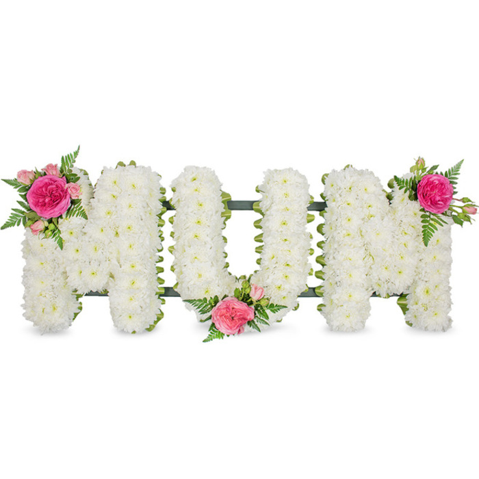 Centred against a crisp, plain white background, the word MUM is spelled out in large capital letters, each one completely covered with compact white chrysanthemum blooms that sit tightly shoulder to shoulder. The flowers form a plush, pillow-like surface, soft and even, with delicate petals curling outwards in small, rounded layers that catch the light in gentle highlights and shadows. The letters are mounted on a sturdy dark green frame, with a ribbon or backing just visible around the base and sides, subtly outlining each shape and anchoring the design. This dark green line keeps the tribute neat and gives a calm, natural contrast to the cool white flowers. To bring warmth and personality, clusters of vivid fuchsia and gentle blush-pink roses have been added by hand. On the first M, a lush garden rose in bright fuchsia is cradled by smaller pink spray roses and tender buds, with airy fern foliage softening the edges. A similar grouping nestles in the lower centre of the U, suggesting a heart at the core of the word, while the second M is crowned at its upper right with matching roses and fern tips, balancing colour from left to right. The composition is simple yet striking, evoking the quiet courtyards and leafy corners around Canonbury where families gather to remember loved ones. The tribute is designed as a funeral or memorial piece, ideal for delivery to local churches, crematoria, or cemeteries, a touching way to honour a mother's life with timeless white chrysanthemums and romantic pink roses that speak of enduring affection and remembrance.