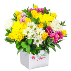 A lush, rounded bouquet of mixed flowers rises generously from a pristine white cube-shaped box, set against a clean white background that makes every petal and leaf appear vivid and defined. The arrangement feels full and luxurious, with a tapestry of yellow, white, and fuchsia tones creating a joyful yet balanced composition. Prominent yellow chrysanthemums with many layered, cushiony petals form a golden canopy, interspersed with clusters of compact yellow roses and rosebuds, some still tightly wrapped, others beginning to open with a hint of fragrance. Between these warm notes, crisp white blooms provide clarity and calm: daisy-like chrysanthemums with bright green centres and fluffy white mums that give height and texture. Weaving gently through the design are rich magenta and fuchsia chrysanthemums, some with soft pink highlights at the tips of their petals, adding depth and a touch of modern flair. Here and there, slender stems of pink and yellow rosebuds tuck between the larger flowers, offering small, romantic details that a trained florist's eye would place with intention. Deep green foliage encircles and supports the bouquet, the leaves smooth and slightly glossy, forming a natural frame that intensifies the brightness of the blossoms. The contemporary white box that serves as the vase is simple and unfussy, allowing the colours above to take centre stage while giving the gift a modern, urban feel that suits Canonbury's mix of period homes and stylish apartments. This image evokes a cheerful floral arrangement ready for local delivery, ideal for marking everyday celebrations, family gatherings, or a thoughtful surprise sent to a friend near Canonbury, De Beauvoir, or along Upper Street.