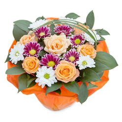 Radiating joy and warmth, this inspired floral arrangement captures the harmonious spirit of Canonbury in early spring. Seen from an overhead viewpoint, the bouquet is a stunning interplay of peachy-orange roses at full bloom, their silky petals spiraling outward with a soft luminosity that mirrors the morning glow filtering through local tree-lined avenues. In between, sprightly white chrysanthemums shine, their crisp, clean petals offering a fresh clarity, while vibrant magenta chrysanthemums add dramatic bursts of colour reminiscent of the floral displays at Canonbury Gardens. Each flower's detail is highlighted by the careful layering of lush, dark ruscus foliage, which acts as a verdant foundation much like the mature greenery across St. Paul's Road. Thin, elegant arcs of decorative grass sweep gracefully above the blooms, creating a sense of airy sophistication. At the base, a wrap of gleaming orange cellophane gathers the bouquet together, providing structure and a splash of celebratory energy. The composition evokes feelings of happiness, anticipation, and shared moments, as if evoking laughter and conversation in a local café after a successful flower delivery. Crafted with a florist's loving expertise, this bouquet is the perfect choice for birthdays, thank you gifts, or any occasion that calls for a thoughtful touch of nature in Canonbury. Each element, from the flower selection to the careful wrapping, reflects a subtle artistry and care that's instantly recognisable to those familiar with Canonbury's vibrant, creative community.