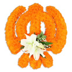 The heart of this floral emblem is tactile warmth and serene contrast: an emblematic shape fashioned from densely clustered bright orange marigolds, their compact, pompom-like heads forming a richly textured field that reads as both symbol and soft landscape. The arrangement's silhouette-carefully modelled to suggest the sacred Khanda-balances the marigolds' generous colour with a tranquil focal cluster of pristine white lilies at the centre where the swords converge. At least two lilies are open, their fleshy petals curving outward to reveal delicate green and yellow stamens, while several smaller lily buds wait to unfurl; together they lend a cool, calming note of scent against the marigolds' warm spicy breath. Interspersed glossy green foliage, possibly salal or magnolia-type leaves, and light clouds of tiny white gypsophila provide visual breathing room, softening edges and accentuating the symbol's contours. The composition rests on a plain white background with a subtle drop shadow, which gives the piece a discreet, freestanding presence and emphasizes the craftsmanship involved in shaping living blooms into a recognisable emblem. Light here is gentle and diffuse, catching the marigolds' layered petals and allowing the lilies' satiny surfaces to glow. Thoughtfully made for ceremonial or commemorative use, this piece evokes gatherings, remembrance, and festival observance-images familiar to families and community groups who gather in Canonbury's nearby parks and halls around Chapel Market, Islington Green and the New River Walk. The overall effect is warm, contemplative and respectful, a floral translation of devotion and community memory.
