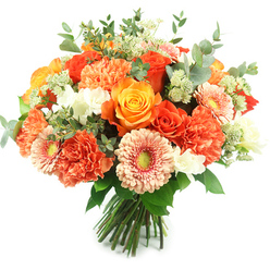 Lit by a soft, natural wash of light that feels like late-morning sunshine, this hand-tied bouquet captures the comforting joy of warm-season blooms. Its classic rounded silhouette is densely packed: large, fully opened roses take centre stage in tones from sunset orange to buttery gold, their velvety spirals offering both visual drama and a heady, honeyed fragrance. Coral and peach carnations fill the spaces between with frothy, frilled petals that invite touch, providing a cushioned contrast to the roses' smooth surfaces. Peach-pink gerbera daisies introduce a playful, open-faced note, their flat petals radiating toward a subtle yellow-green centre that brightens the eye. Sprays of small white accent flowers - delicate freesia-like or tiny chrysanthemum clusters - float among the blooms and add crisp highlights, while pale green Astrantia-like clusters and feathery filler foliage bring a light, textural lift. The bouquet is anchored by cool-toned eucalyptus leaves, their rounded, grey-green shapes creating restful negative space and a fresh, resinous scent beneath the sweeter florals. Stems are gathered and bound at the base in the thoughtful style of a neighbourhood florist, making it easy to place in a vase for a mantel on Essex Road or to bring as a cheerful gift to a friend on Upper Street. The overall feeling is one of considered craftsmanship and gentle celebration - a floral moment that feels both elegant and intimately familiar to Canonbury homes.