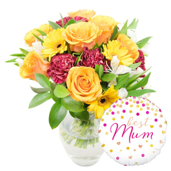 A joyful, professionally composed bouquet with a matching celebratory balloon, pictured against a pristine white background and imagined through the eyes of a Canonbury florist preparing same-day deliveries across the area. The arrangement is dominated by several full, apricot-orange roses whose layered, spiralling petals open into generous cups, their scent soft and reassuring. Interwoven are bright yellow gerbera daisies, their radiating petals and dark centres offering sunny punctuation, while richly coloured maroon carnations introduce a dense, velvety texture that grounds the warmer tones. Delicate white alstroemeria - each petal tipped with faint speckling - provides lightness and a subtle citrusy fragrance that lifts the bouquet. A variety of fresh greenery, from broad glossy leaves to narrow, feathery sprigs, forms a verdant cradle, giving the composition both structure and an informal, garden-fresh feel. The flowers are gathered in a clear glass vase so clean that the trimmed stems and fresh water are visible, a little detail that signals care in arranging. Nestled to the lower right and slightly overlapping the vase, a round white foil balloon decorated with scattered gold and hot-pink dots and tiny hearts carries the handwritten-style message 'best Mum' in vivid fuchsia script. The whole picture reads as a thoughtful token of appreciation - perfect for Mother's Day, a birthday, or a surprise delivered to a flat near Essex Road or a house by Newington Green - and is the sort of heartfelt offering Canonbury Flowers might prepare when customers ask for something bright, personal, and unmistakably celebratory.