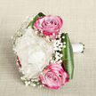 Resting on a pale, gently crumpled linen backdrop, this intimate hand-tied bouquet feels like a quiet moment before a Canonbury wedding begins. In the centre, a sumptuous creamy white peony opens generously, its many layers of softly cupped petals creating a billowy, almost cloud-like bloom that suggests luxury without loudness. Framing it above and below, two vivid pink roses add a note of passion: their tightly swirled hearts glow in lighter blush tones, while the outer petals shift toward deeper fuchsia, as if brushed with evening light over nearby Islington townhouses. Threaded between and around these focal blooms are fine tendrils of baby's breath, their tiny white flowers forming a delicate halo that introduces texture and a sense of movement, like gentle breeze through the trees on Canonbury Road. Holding everything together, broad, dark green leaves curve smoothly around the base, their sheen and strong lines grounding the ethereal blossoms with a polished, contemporary edge. The stems are gathered in the florist's hand and meticulously wrapped with white satin ribbon, forming a clean, bridal handle that looks ready to be lifted for a walk to a ceremony near New River Walk. Crafted with the care you'd expect from a local studio such as Canonbury Flowers, this bouquet captures romance, freshness, and understated celebration, ideal for wedding features, engagement inspiration, or editorial pieces on elegant London floral trends.