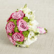Set against a softly textured, light beige backdrop that resembles finely woven linen, this hand-crafted bouquet lies gently on its side, as if waiting to be lifted for a walk to the ceremony along Canonbury's tree-lined streets. The central focus is a cluster of opulent pink roses, each bloom layered with petals that move from a delicate, powdery blush at their hearts to richer pink and magenta tones on the outer edges. Their velvety spirals feel both romantic and confident, the kind of roses a Canonbury florist might choose for a couple celebrating their vows nearby in Islington. Nestled among these roses are vivid lime green button chrysanthemums, tiny florets packed closely together into perfectly rounded domes. Their crisp, fresh colour adds energy and playfulness, like a burst of spring in Arlington Square. To the right, a drift of white lisianthus softens the composition, their ruffled petals opening in creamy and pure white layers. Some blooms are fully unfurled, while others remain in slim, upright buds, adding height and a sense of gentle movement. The stems are bound into a compact handle, meticulously wrapped in blush pink satin ribbon. Over the ribbon, loops of luminous white pearls spiral in elegant lines, evoking a treasured bracelet or family heirloom worn on the wedding day. The neutral, crosshatched fabric background stays discreet, allowing the pink, green, and white palette to shine. Together, the flowers create an image of poised, tender celebration, ideally suited for a Canonbury wedding bouquet or special-occasion delivery across N1.