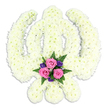 Depicted here is an elegant Sikh Khanda funeral tribute, crafted with the kind of precision and care you might expect from Canonbury Flowers when serving local families around Essex Road or Highbury Corner. The entire religious emblem-the upright central sword, the circular chakkar around it, and the two outward-sweeping kirpans-is sculpted from a thick carpet of white chrysanthemums. Each bloom is tightly set against its neighbour, so the surface appears plush and continuous, like a soft white tapestry. The petals are slightly ruffled, catching the light in gentle highlights and shadows that reveal the curvature of the symbol's blades and ring. The overall impression is one of purity and stillness, as though the flowers have been arranged to offer a calm, unspoken blessing. At the lower centre of the Khanda, in the cradle formed where the kirpans cross, sits a small but striking accent bouquet. Three pink roses, open and full, form the heart of this grouping, their petals layered in spirals of blush and rose tones that hint at tenderness and affection. Around them cluster small, deep purple flowers, likely lisianthus or similar delicate blooms, whose cool, regal colour lends a sense of quiet dignity. Green fern fronds and leaves spread softly around the flowers, framing the colours and leading the eye back to the smooth white of the main tribute. The background is a clean, uninterrupted white, and a faint shadow beneath the arrangement gives it a sense of gentle weight, as if it has just been placed in a serene room before a Sikh memorial service. This Khanda design captures the feelings of devotion, courage, and loving remembrance that families in Canonbury may wish to convey during times of loss.