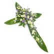 Viewed from a gentle overhead angle against a clean white background, this solemn floral cross reads as a quiet, reverent statement in green and soft pastels. Large, glossy tropical leaves - reminiscent of Ti leaves - form the defined arms and central spine of the Christian cross; their broad shapes overlap with visible veins and a satiny sheen that catches the light and gives the piece a calm, structured foundation. Centered where the arms meet is a densely gathered cluster of blooms in creamy ivory and pure white: ruffled lisianthus with multiple, soft, unfurling petals, small round chrysanthemum or spray-rose-like blooms that add brightness, and delicate closed buds that suggest gentleness and restraint. Sprays of tiny lavender-hued aster or limonium are threaded through the white, their star-like faces introducing a cool, comforting contrast that deepens the composition without overpowering it. Fine green filler foliage is tucked between blossoms, lending a natural, airy texture and softening edges where the floral mass meets the leaf base. The lighting is even and soft, revealing subtle shadows beneath layers of petals and the waxy gloss of the leaves, while the overall palette remains tranquil - a restrained interplay of white, cream, pale purple and deep green. As a florist in Canonbury I picture this arrangement placed beside a chapel hymn book or at a graveside service on Canonbury Square: it conveys calm respect, solemn remembrance and hope. The piece feels tactile and quiet, scented faintly of fresh green foliage and the mild sweetness of lisianthus, making it an appropriate tribute for funerals, memorial services, or a dignified floral offering in moments of mourning.