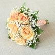 A classic bridal bouquet in creamy peach tones, styled with the attentive hand of a local Canonbury florist and inspired by the neighbourhood's quiet squares and New River meadows. Six lush peach roses form the compositional centre, each bloom opening with soft, velvety layers that graduate from warm apricot to a pale, creamy heart. Surrounding them, froths of tiny white gypsophila float like spun mist, lifting the palette and lending a breathy, innocent halo to the roses. Emerald-green leaves, glossy and smooth, peek through the cloud of baby's breath to provide depth and a cooling contrast that makes the peach hues glow. The stems are gathered and swathed in peach satin ribbon, the handle finished with a single string of pearls that glimmer gently-an elegant, tactile detail that invites a bride's fingers to linger. Fresh from our Canonbury Flowers studio near Essex Road, the bouquet has a subtle, natural fragrance reminiscent of early garden mornings: soft, floral, and clean. It feels light and secure in the hand, balanced for a ceremony walk yet beautiful enough to rest in a keepsake box. Whether pictured against the cobbles of Canonbury Square or the pale stone of a local church, this arrangement reads as timeless, tender, and handcrafted with neighbourhood care-perfect for weddings, anniversaries, or any moment that warrants a quiet, refined celebration.