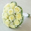 Captured in gentle daylight and embracing the classic beauty that defines Canonbury gatherings, this close-up bridal bouquet features a densely packed, artful arrangement of creamy yellow and off-white roses-each blossom pristine, fresh, and at the height of bloom. Interspersed throughout, an abundance of delicate white gypsophila brings a cloud-like softness to the bouquet, evoking the first hint of dawn mist over Highbury Fields. Elegant arcs of slender, deep green bear grass curl gracefully around the roses, adding both vibrant contrast and a modern sculptural accent beloved in Canonbury floral design. The flower stems, bound securely and wrapped in pure white satin, provide a comfortable handle inviting to the touch, while the bouquet itself is displayed diagonally atop a softly textured background reminiscent of a cream linen tablecloth. Each visual detail speaks to sophistication and timeless romance-a bouquet designed not only for weddings but for any occasion where love and appreciation are celebrated across Canonbury's leafy avenues. The composition's tender fragrance and airy beauty offer a quiet moment of joy and hope, ideal for those seeking both classic charm and local expertise.