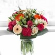 This handcrafted bouquet, arranged fresh by Canonbury Flowers for local delivery across N1, embodies a burst of celebration-a moment of vibrant joy captured in blossoms. Spirited orange gerberas radiate warmth and positivity, their faces bright as a summer afternoon in Canonbury. Alongside them, blushing pink and creamy ivory roses add romantic softness, balanced by the rich, velvety depths of magenta carnations. Soft peach gerberas complete the palette, bringing an air of elegance and gentle tenderness reminiscent of tranquil walks past the Regent's Canal. The supporting greenery is deep and glossy, boldly framing the floral colours with a lush abundance echoing the mature trees of Canonbury Square. Illuminated by crisp, bright light, each petal is alive with delicate vein patterns and subtle tonal shifts, making the bouquet feel almost luminous. This arrangement is perfect for commemorating milestones-a birthday, an anniversary-or simply for delivering happiness and harmony to a neighbour or loved one in the heart of Canonbury. In every petal, the expert floristry and neighbourhood spirit shine through.
