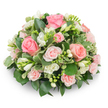 A soft, dome-shaped tribute of pale pink and white blooms, pictured against a clean white background so every petal and leaf reads clearly. At the centre are classic pink roses - a mix of full, velvety blooms and smaller spray roses - their petals unfurling from blush to a warmer salmon-pink, offering a tactile, almost satin softness. Interspersed through the rose canopy are clusters of pure white freesia: slender, bell-shaped flowers both open and in tight buds, their subtle lemony fragrance hinted at in the visual rhythm of closed and revealed petals. The arrangement is dense and cushion-like, the blooms packed close together so no stems show; instead a backdrop of glossy dark greens (think ruscus or salal) forms a deep, calming base while variegated leaves edged in cream - likely pittosporum - flicker like quiet highlights. Natural, soft daylight sculpts gentle shadows across the rounded surface, emphasising texture and the neat, formal silhouette. The overall effect is one of refined tenderness - a composition that reads as both comforting and composed - suitable for a memorial service, a bedside get-well gift, or as a serene centrepiece for a small, intimate gathering. A florist's hand is evident in the meticulous balance of colour and foliage: every bloom placed to give depth, promise, and a slow, unfolding beauty. For anyone in Canonbury seeking a sympathetic, understated floral message, this arrangement conveys quiet consolation and measured affection, recalling gentle mornings in nearby Canonbury Square and the calm of the New River Walk.