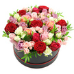A black round hat box brimming with roses is shown against a spotless white background, creating a striking contrast that highlights the richness of the blooms. The roses are arranged in a lush, domed silhouette that spills just above the rim of the box, every space carefully filled so only petals and a touch of greenery are visible. The colour palette sweeps through classic deep red, soft blush and bright fuchsia pinks, gentle creams and clean whites, sunlit peach and coral hues, and graceful lavender and mauve tones that add a cool refinement. Each rose appears freshly cut, with velvety petals that spiral delicately; some blossoms are fully open and generous, while others remain slightly closed at the heart, giving the impression of a bouquet still in the process of unfolding. Nestled between the larger heads are clusters of smaller spray roses, their petite blooms adding texture and an intricate, almost lace-like detail. Bright green leaves pierce the dome at intervals, their small, pointed forms providing welcome contrast and a sense of natural movement across the surface. The hat box is smooth and matte, a deep black cylinder encircled at the base with a subtle red trim or ribbon, which visually anchors the design and quietly echoes the richest red roses. With no table, room, or props shown, the eye rests solely on the floral composition, inviting thoughts of how it might look on a dining table in Canonbury, by a window near Highbury & Islington station, or in a living room off Upper Street. The overall feeling is one of romantic generosity and polished elegance, perfectly suited to anniversaries, birthdays, or an expressive I'm thinking of you sent within the local area.