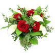 A dramatic yet elegant bouquet of red roses and white calla lilies is displayed in a clear cylindrical glass vase, its rounded form framed by an abundance of lush greenery and set against a clean white background. At the centre, six or seven roses in a rich, saturated crimson open fully, each flower composed of velvety petals that curl outwards in intricate spirals, creating a sense of depth and softness reminiscent of the historic brick façades around Canonbury Place. Interwoven among these roses, several calla lilies rise with quiet grace, their elongated, trumpet-shaped blooms rendered in smooth, creamy white, each one enclosing a slim, warm yellow spadix that draws the eye without overpowering the scene. The supporting foliage brings structure and texture: sprigs of eucalyptus with soft, silvery-green, coin-shaped leaves weave between the blooms, while broader, darker emerald leaves provide a lush underlayer, much like the foliage-heavy corners of nearby Highbury & Islington's green spaces. The stems are visible through the transparent vase, gathered with precision and submerged in clear water, reinforcing the impression of a freshly made arrangement, ready to leave a Canonbury florist's workbench for delivery to a home along the quiet residential streets. Bright, even lighting accentuates the interplay of textures-the satin sheen of the calla lilies, the velour feel of the roses, and the slightly waxy gloss of the leaves-while the stark white background keeps all attention on the bouquet's refined lines and colour harmony. The mood is one of understated luxury and sincerity, ideal for a heartfelt anniversary gesture, a romantic surprise, or a sophisticated focal point on a dining table for an intimate gathering.