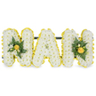 A carefully shaped, three-dimensional funeral tribute reads NAN in bold capital letters, each letter built from a dense carpet of small, pristine white chrysanthemum sprays that give the surface a cloud-like, pillowy texture. Around the edge of every letter runs a bright halo of smaller yellow blooms - button chrysanthemums or tiny carnations - their cheerful hue neatly outlining each stroke and adding a vibrant, sunlit edge to the design. The two N letters are softly dressed with compact accent clusters of glossy deep-green foliage and brighter yellow buds, anchored by tight, warm-hued rosebuds that sit like quiet focal points against the white. The central A is intentionally left unadorned, its pure white face and yellow border offering a restful simplicity amid the more detailed upright letters. A discreet dark-green or black horizontal support bar runs behind the upper sections, connecting and steadying the letters for freestanding display at a funeral plot or chapel service. Set against a clean white background and photographed in soft, natural light, the arrangement's textures - the papery chrysanthemum petals, the satiny small yellow blooms, and the glossy leaves - are easy to imagine by touch. The overall mood is one of gentle remembrance: white for purity and quiet respect, yellow for warmth and the bright memories of a loved grandmother. As a Canonbury-area florist might suggest when preparing tributes for St. Paul's Road or graveside services near Highbury Fields, this composition balances dignity and tenderness, offering a personal and comforting visual farewell that speaks of love, memory, and the small, sunlit moments that endure.
