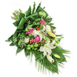 This diagonal floral spray, abundant in fresh Canonbury-sourced stems, carries a sense of quiet comfort and heartfelt tribute for those tender moments of remembrance. The arrangement's elegant composition flows naturally from upper left to lower right, echoing the gentle avenues of the neighbourhood and the tranquillity found in Canonbury's green spaces. Creamy white lilies, both in full bloom and promising buds, take centre stage, their golden stamens catching soft light and evoking a mood of purity and peace. Among them, blushing pink roses gently unfold, each petal layered with memory and warmth; their fuchsia tones stand out, while airy clusters of white spray carnations bring softness and volume throughout. Rounded green chrysanthemums add a modern, textured vibrancy, like the verdant gardens tucked behind Canonbury's terraced homes, and bright scarlet hypericum berries spring up as cheerful accents, offsetting the arrangement's cooler hues. Deep green leaves-some broad and glossy, others feather-light-give depth and create a lush background, the long palm fronds at the base guiding the eye along the spray's natural cascade. Illuminated by gentle daylight, every element, from structural aspidistra folds to the rustic ruscus, testifies to the experience and care of Canonbury's floral experts. This arrangement is a moving choice for a funeral, memorial, or as a sympathy offering-delivered with compassion and dignity, embodying the thoughtful spirit of Canonbury.