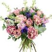 The photograph captures a lavish, hand-tied bouquet isolated against a plain white background, its rounded shape and intricate detail reminiscent of an elegant gift being carried home from a Canonbury florist after a special occasion. The colour palette blends soft pastels with deeper jewel tones: at the centre, generous roses in dusty pink and pale peach bloom in layered spirals, some fully open and others still holding their petals more tightly, hinting at days of enjoyment ahead. Around them, plush carnations with frilled and fringed petals introduce a dynamic texture, their two-tone colouring shifting from vivid, almost fuchsia-magenta at the edges into creamy blush at the core. Scattered among these romantic tones are striking indigo and violet-blue anemones, each one marked by a dark, velvety centre that draws the eye and adds a refined, contemporary contrast. Slender stems of lavender and pale pink stock emerge through the arrangement, their numerous petite florets creating a cloud-like softness and suggesting a gentle, powdery fragrance, like walking past the planted borders near Canonbury Square on a mild evening. The whole bouquet is cradled in a frame of greenery, with rounded, silvery eucalyptus leaves cooling the palette and darker green foliage adding body and depth. The natural stems are gathered at the base in a tight hand-tied finish, their varying greens and woody tones clearly visible and reinforcing the freshly arranged, artisan feel. Even, bright lighting illuminates each petal edge and vein, highlighting the bouquet's velvety textures and harmonious colours. This composition feels ideal for birthdays, anniversaries, or simply brightening a Canonbury home with a touch of romantic, understated luxury.