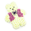 A teddy bear made entirely of flowers sits at the centre of a bright, white frame, its presence both playful and deeply comforting. The bear's form is sculpted from countless creamy white chrysanthemums, tightly massed to create a rounded head, softly curved ears, stout arms, and solid little legs that give the figure a pleasing, toy-like proportion. The petals blend into one another, forming a velvety surface that recalls the feel of brushed plush or fleece. In the middle of the face, small dark eyes and a compact triangular nose provide definition and character, giving the bear a gentle, reassuring gaze. A subtle curve beneath the nose suggests a quiet smile, the kind that offers calm rather than cheerfulness, perfect for tender moments of remembrance. Across the chest, a waistcoat of deep pink, mauve, and magenta flowers-likely hydrangea or richly coloured chrysanthemums-has been carefully assembled, splitting into two neat panels that look like miniature lapels. At the collar where these panels meet, a fine purple net bow sits gracefully, its sheer loops catching the light and introducing a delicate, almost gossamer texture. The neutral white backdrop keeps all focus on the bear, amplifying every tonal shift from cream to pink to violet. Imagined in the context of Canonbury, this floral teddy might rest beside a small casket in a local chapel, be delivered to a family home off Canonbury Road, or placed at a memorial near the quiet paths by Canonbury Gardens. It holds the essence of childhood innocence and love, translated into petals that whisper comfort and remembrance.