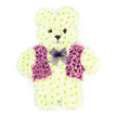 In this image, a lovingly crafted floral teddy bear sits against a pure white backdrop, a tender and personal tribute often chosen for funerals or memorial services in Canonbury. The bear's entire figure-head, ears, rounded tummy, arms, and legs-is constructed from tightly packed creamy white chrysanthemums, arranged so smoothly that they resemble the plush coat of a much-loved soft toy. The blooms are uniform in size and tone, giving the bear a calm, cohesive appearance, with the petals forming a subtle, velvety texture that invites the imagination to reach out and touch. Small dark floral disks mark the eyes and nose, lending the teddy a gentle, slightly wistful expression, while a faint, petal-formed mouth curves into a soft, reassuring smile. The most striking detail is the bear's vest, composed of rich purple and mauve flowers that lie flat but full, creating a neat, tailored shape over the chest with defined lapels that suggest care and formality. Around the neckline, a delicate lavender mesh bow rests lightly, its fine netting catching the light and offering a graceful, almost airy counterpoint to the dense floral body. With no distractions in the background, each element of the design stands out: the symmetry of the limbs, the rounded ears, the crisp outline of the vest, and the carefully balanced colours. Imagined as it might appear on a stand at a Canonbury memorial service or arriving by local delivery to a family home near Upper Street, this floral sculpture is quietly expressive, bringing together childhood comfort, soft colour, and expert floristry to honour a life with dignity and love.